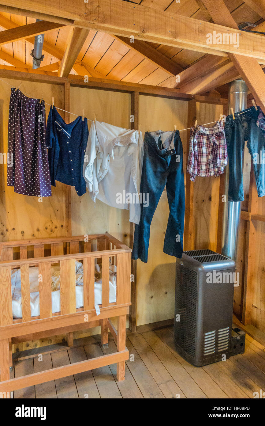 Manzanar vivienda interior con un tendedero con ropa recién lavada colgada  de ella, un pequeño calefactor y una cuna de madera Fotografía de stock -  Alamy