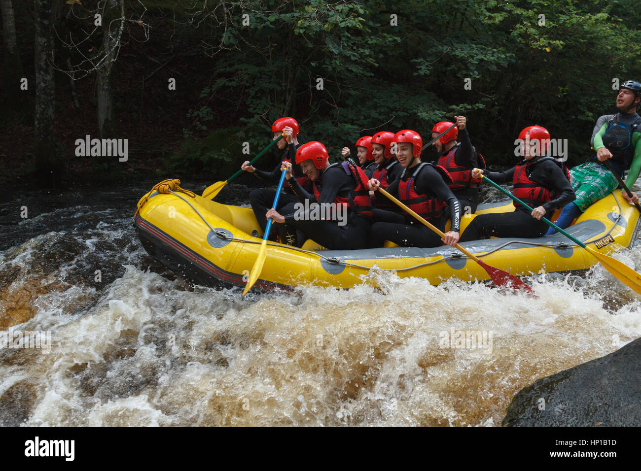 Vigas de agua blanca disparar los rápidos en el Centro Nacional de Aguas Blancas en el río Tryweryn una popular actividad de grupo o team building Foto de stock