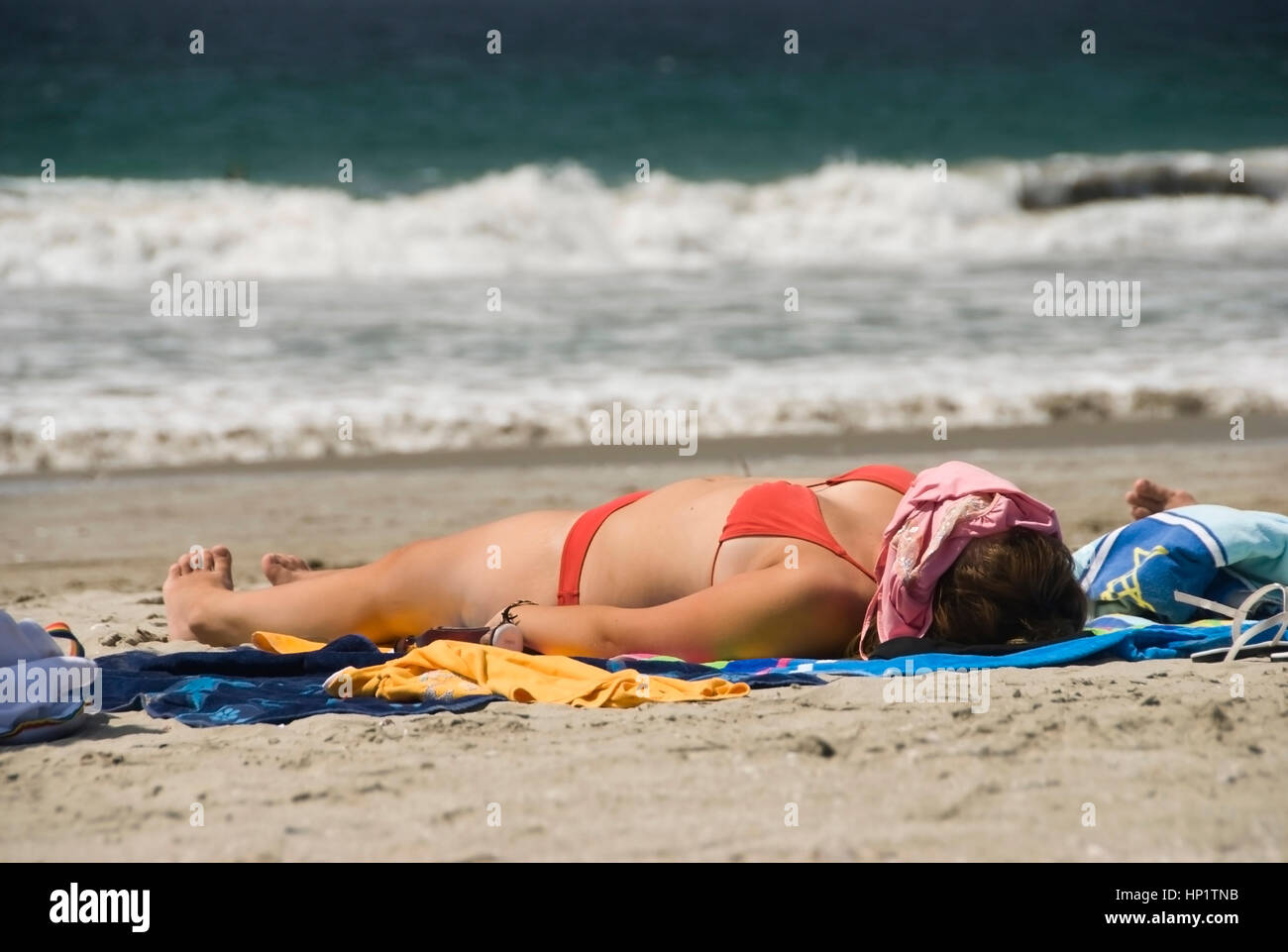 Frau im Bikini sonnt sich am Sandstrand suns - la mujer en bikini en la playa Foto de stock