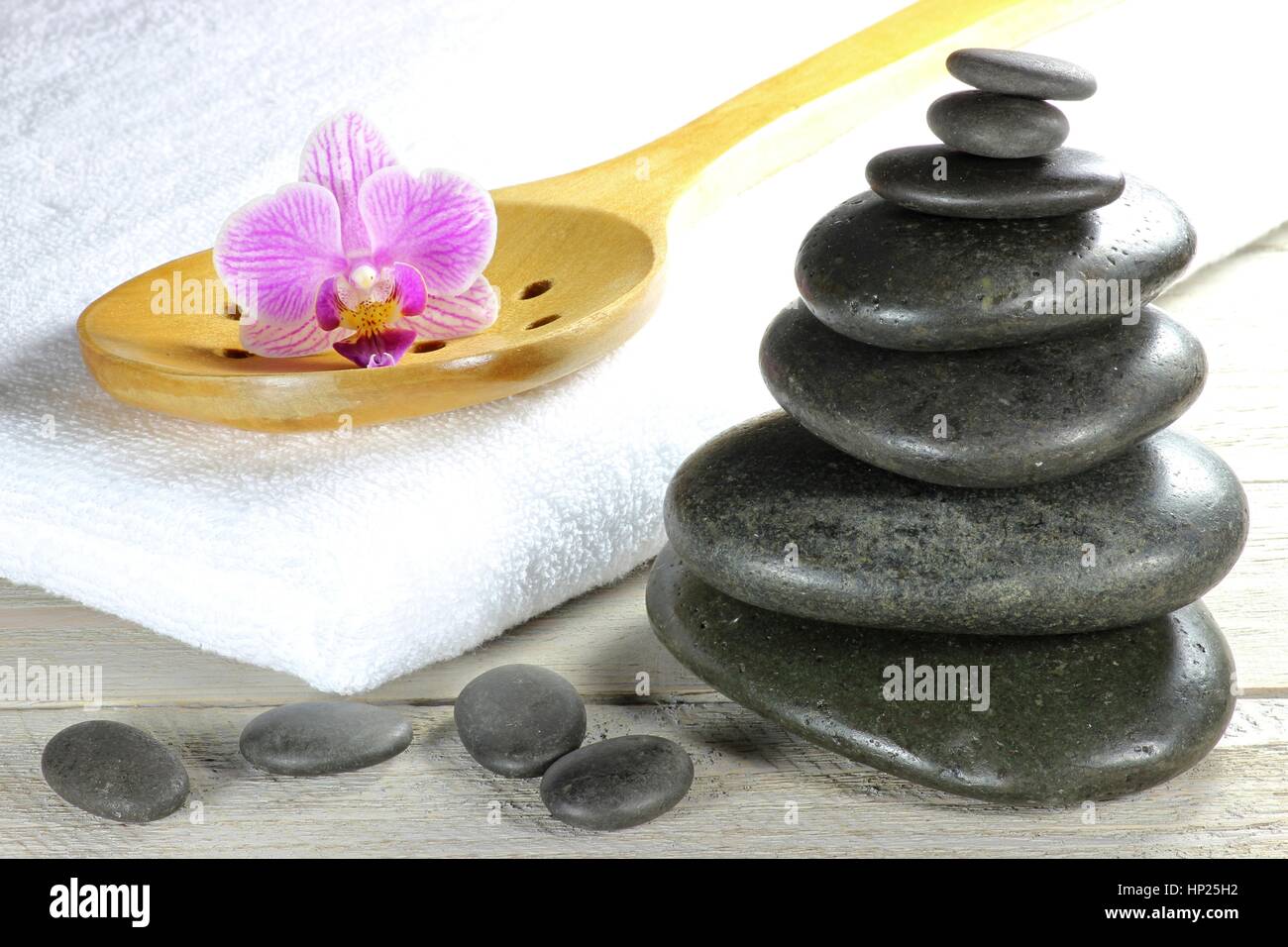 Piedras de basalto para masajes con piedras calientes accesorios sobre  fondo de madera Fotografía de stock - Alamy