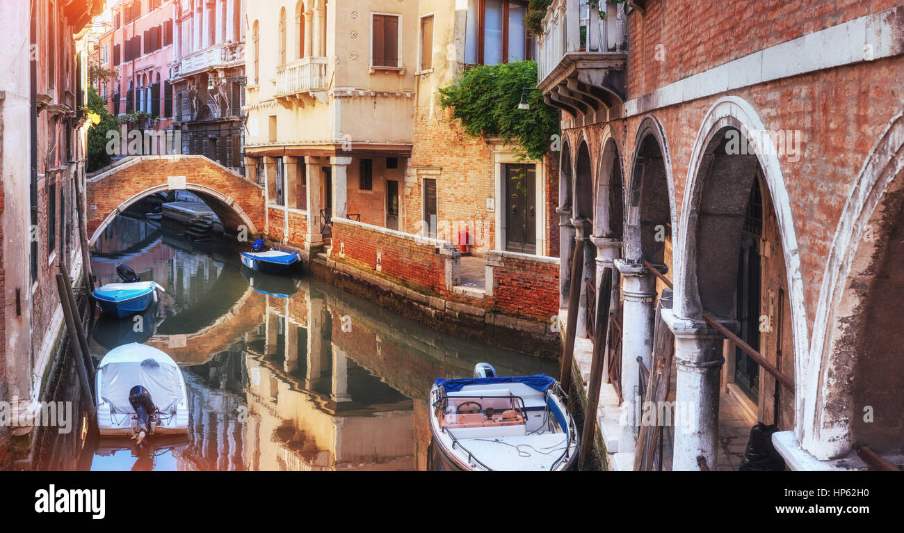 Las góndolas tradicionales en un estrecho canal entre coloridas casas históricas en Venecia Italia Foto de stock