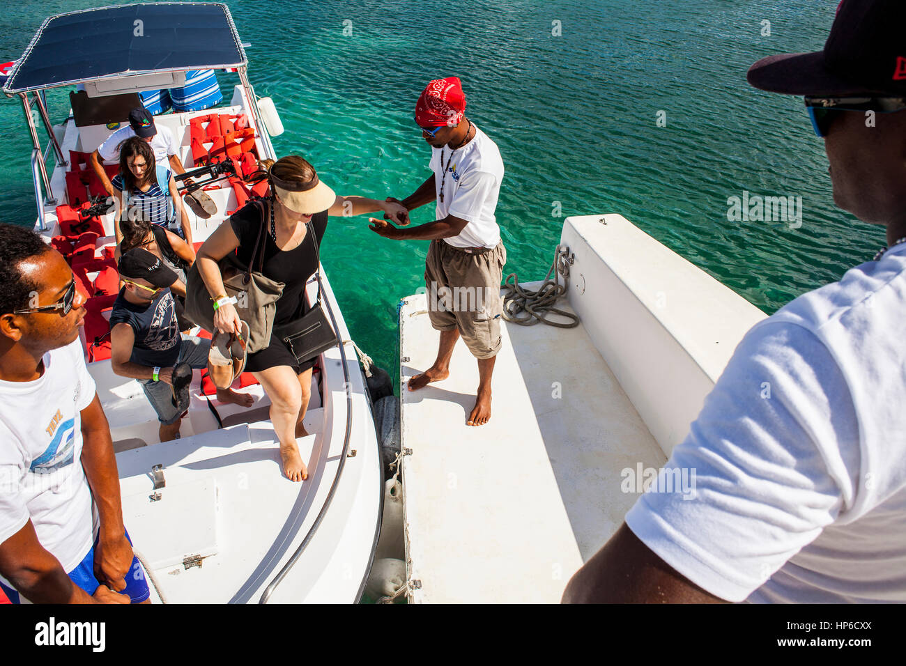 Yendo a la Isla Saona, Crew ayuda a los turistas a subir al catamarán, Puntacana, República Dominicana Foto de stock