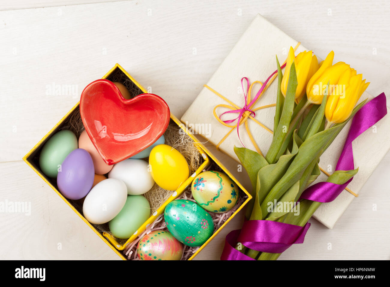 Coloridos tulipanes y huevos de Pascua decorados con bellos giftbox con cintas Foto de stock