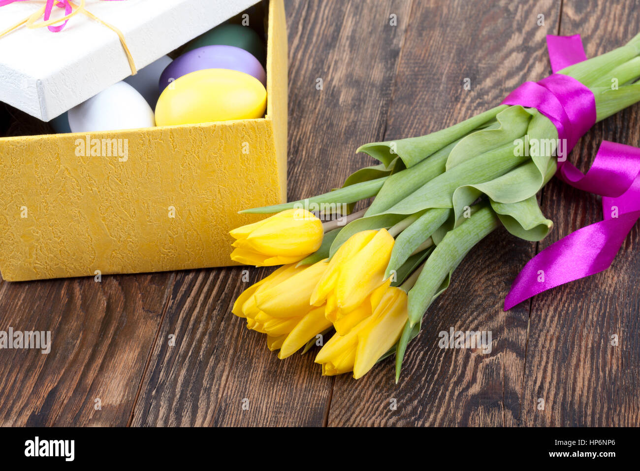 Coloridos tulipanes y huevos de Pascua decorados con bellos giftbox con cintas Foto de stock