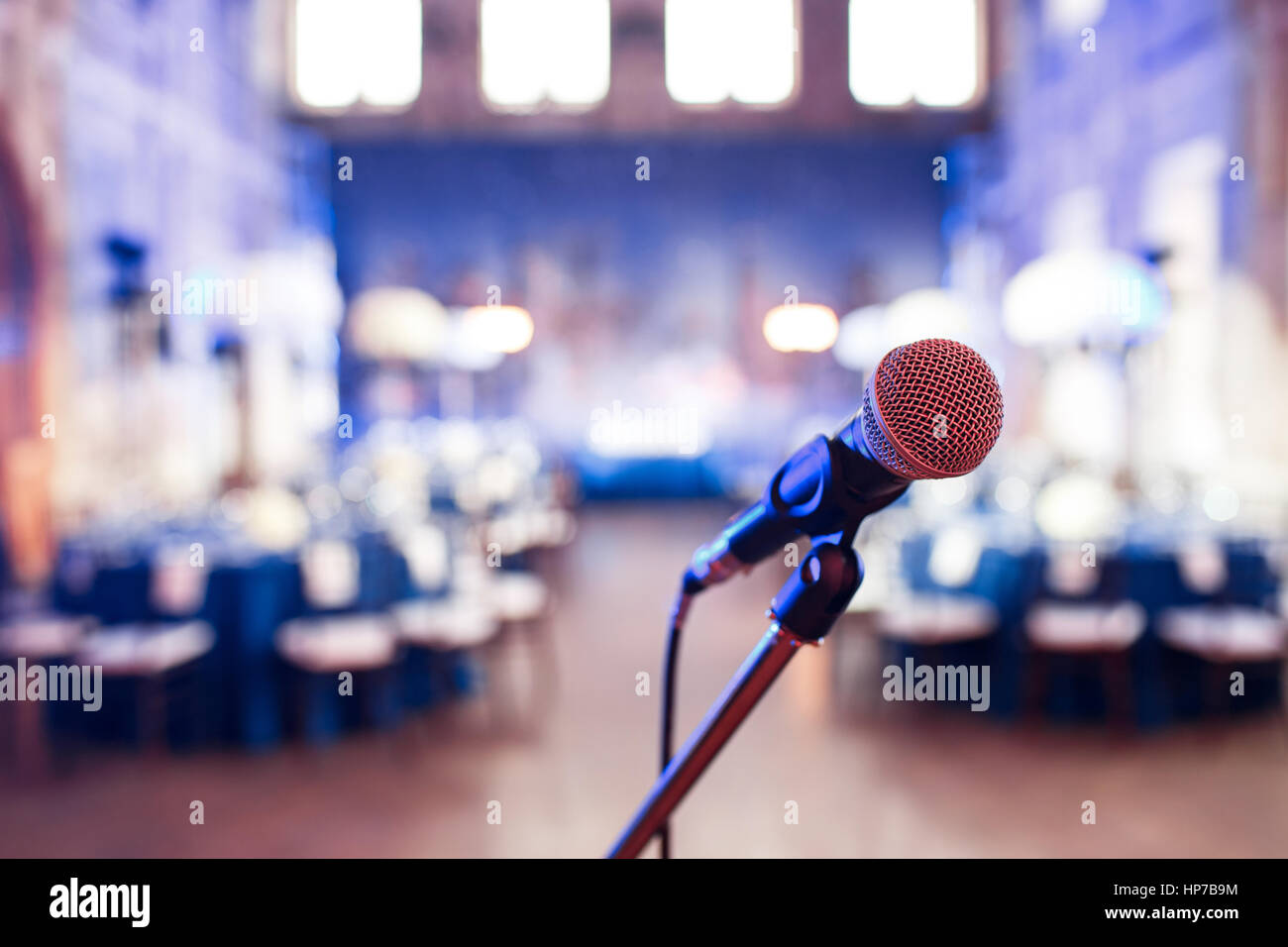 Micrófono sobre la fotografía borrosa abstracta del salón de conferencias o banquetes de boda antecedentes Foto de stock