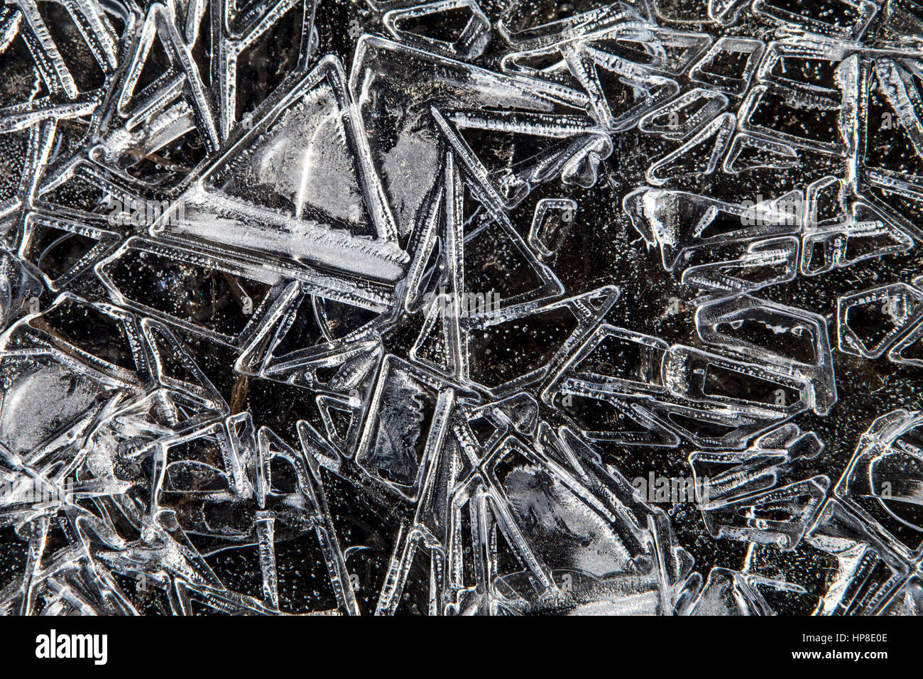 Cristal de hielo macro con patrones naturales y un triángulo, se encuentran en una playa de Alaska en invierno. Foto de stock
