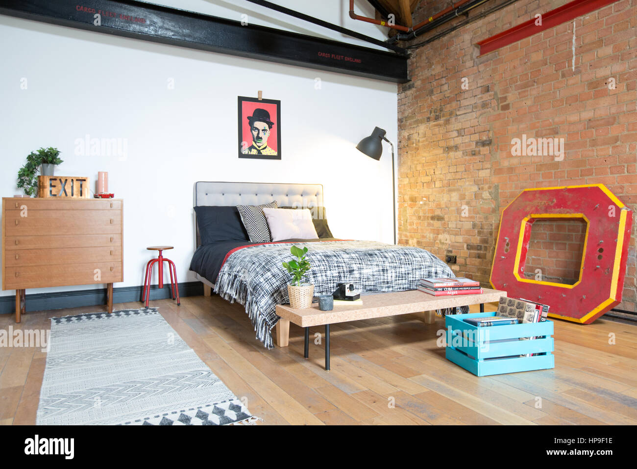 Una habitación en un apartamento estilo loft con ladrillo y muebles midcentury Foto de stock