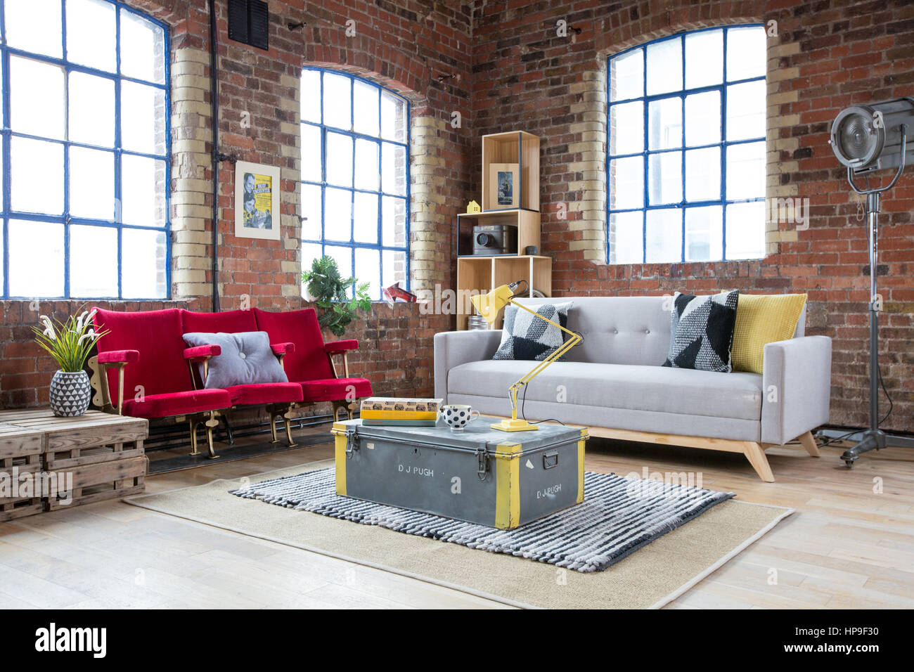 Una sala de estar en un apartamento de estilo almacén con paredes de ladrillo y sillas de cine Foto de stock
