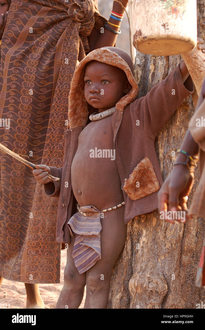 KAOKOVELD, Namibia - OKT 13, 2016: desconocidos Himba muchacho en una pequeña aldea. El niño está ayudando a proteger a las vacas. Foto de stock