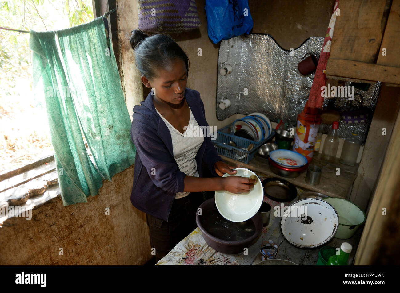 Mujer joven lava platos, hogar, la provincia de Fianarantsoa, Madagascar Foto de stock