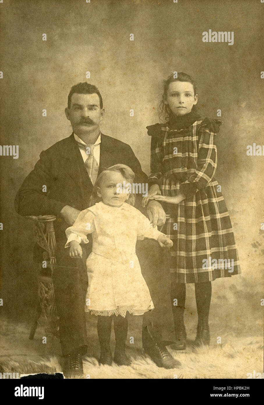 Antique c1890 fotografía, padre y dos hijas, de 4 y 9 años aproximadamente. Fuente: impresión fotográfica original. Foto de stock