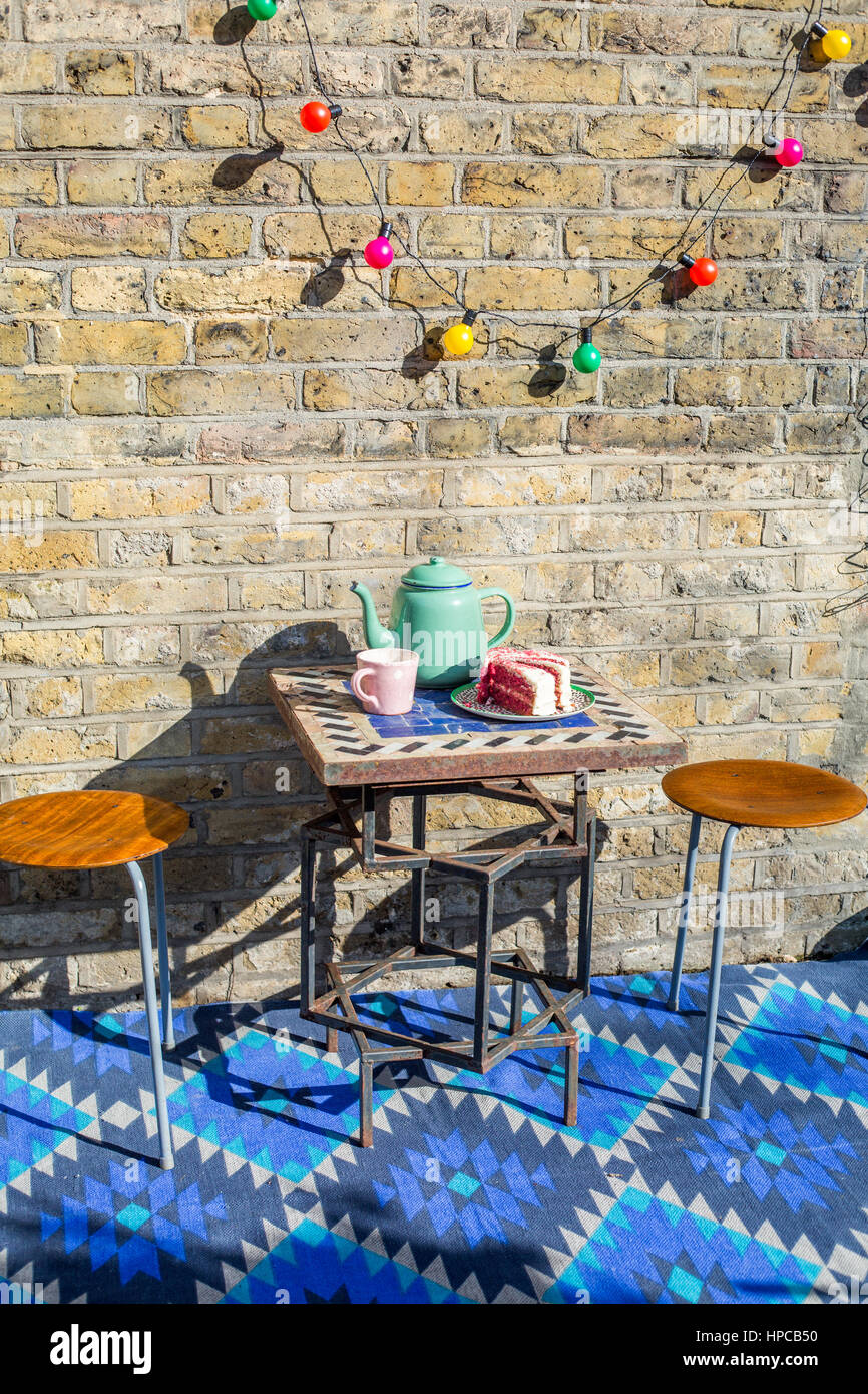 Té y bizcocho en un elegante jardín contemporáneo Foto de stock