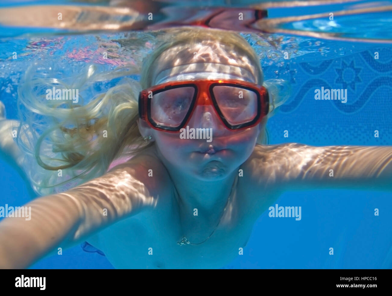 Maedchen mit Taucherbrille schwimmt Unterwasser - chica con buceo googles nadando bajo el agua. Foto de stock