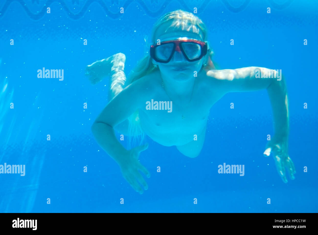 Maedchen mit Taucherbrille schwimmt Unterwasser - chica con buceo googles nadando bajo el agua. Foto de stock