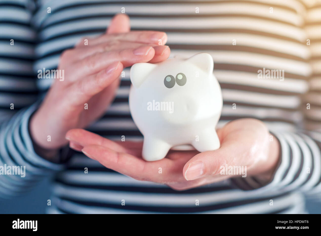 Mujer abraza piggy Coin bank, responsable home presupuestación y ahorrar dinero Foto de stock