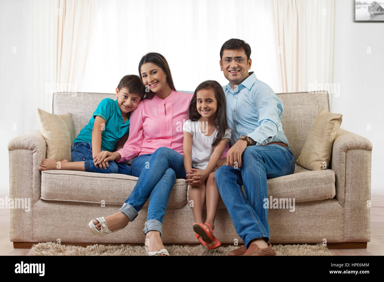 Retrato de familia con dos hijos en el sofá Foto de stock