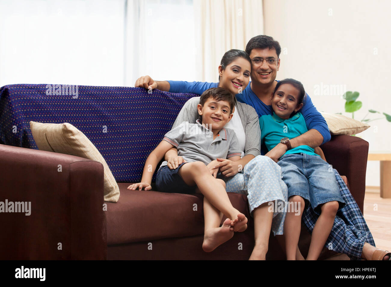 Retrato de familia con dos hijos en el sofá Foto de stock