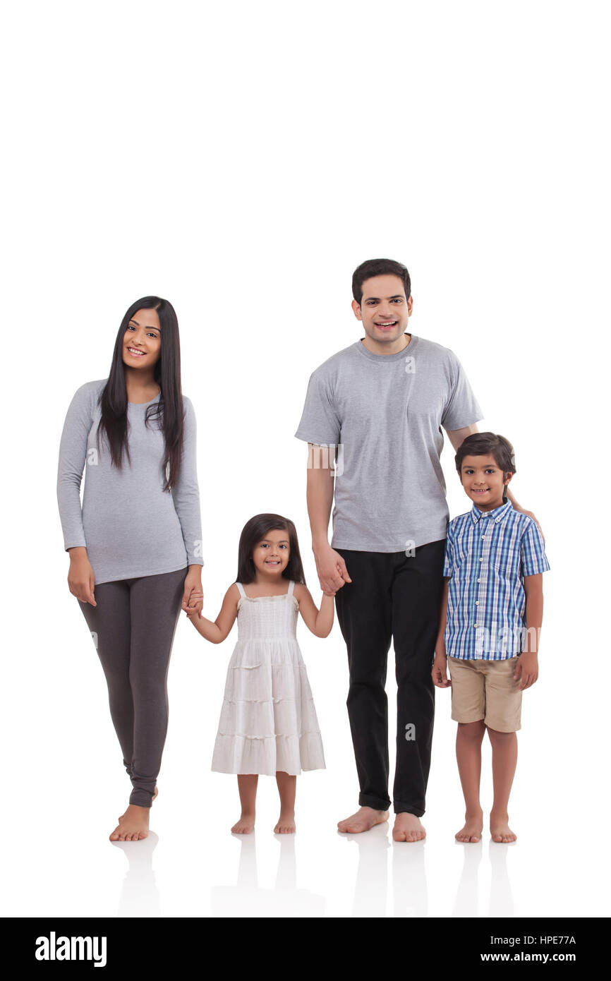 Familia con dos niños que posan juntos Foto de stock