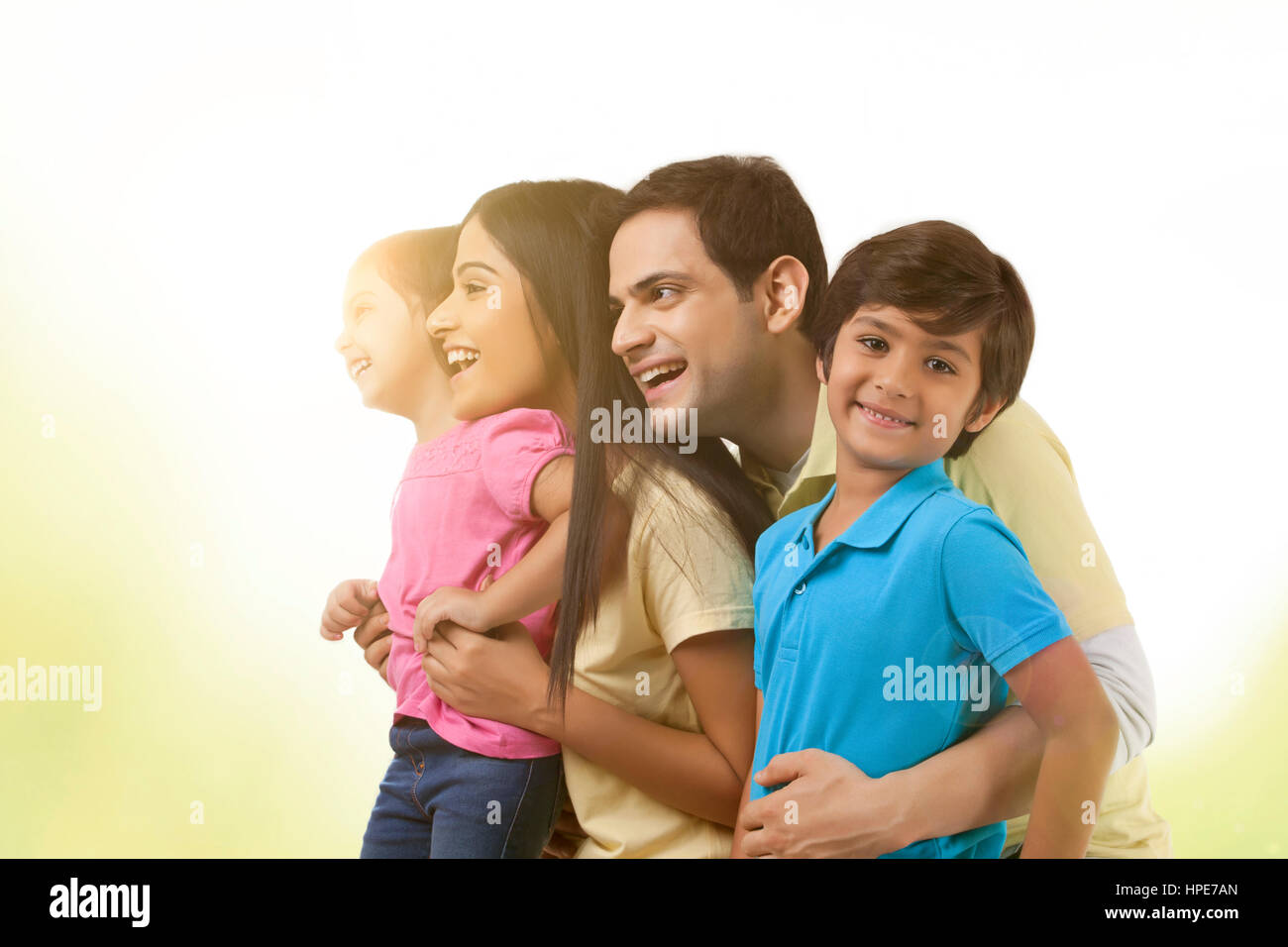 Vista lateral de la feliz familia joven contra el cielo claro Foto de stock