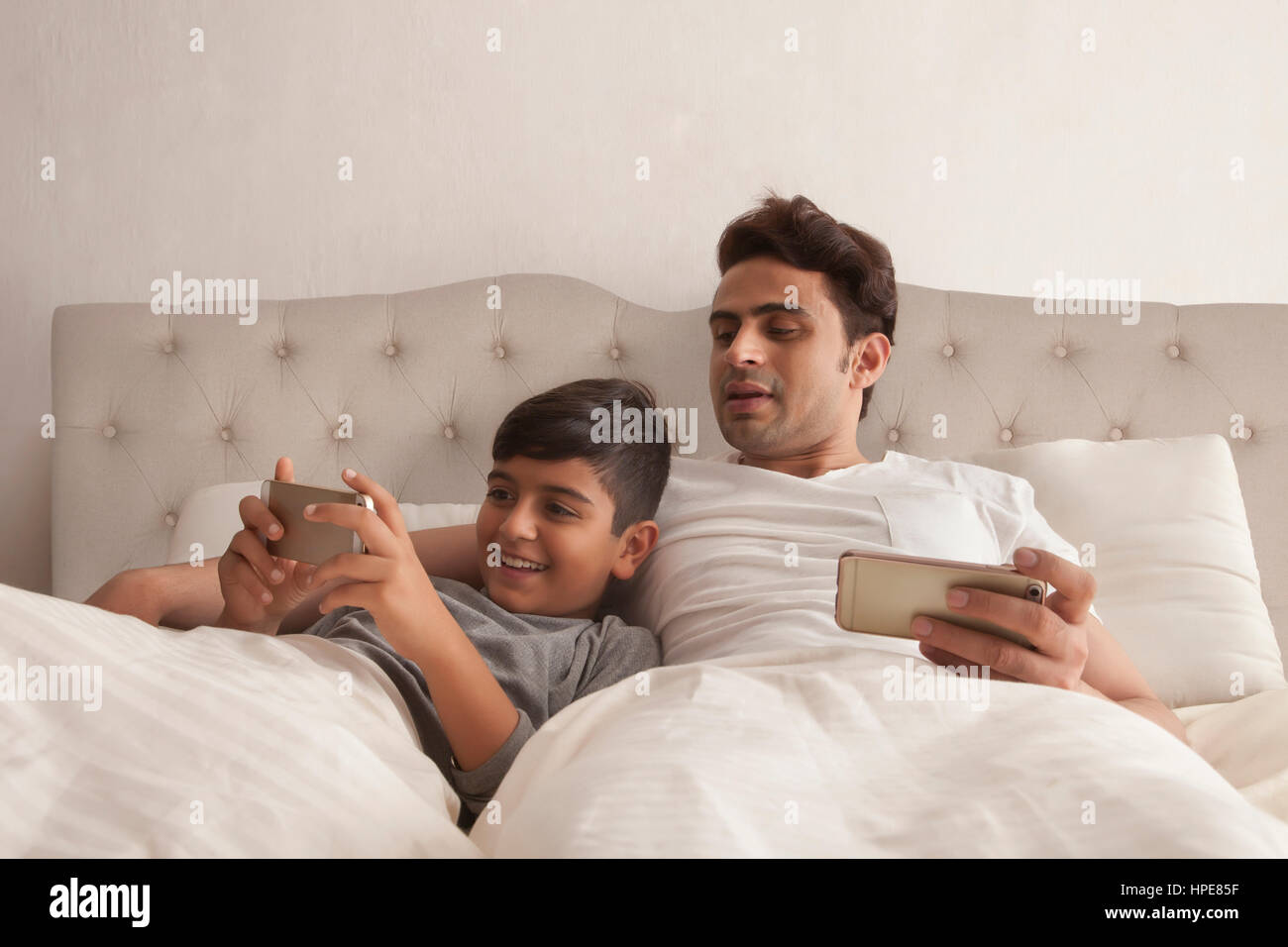 Padre e hijo con teléfonos inteligentes. Foto de stock