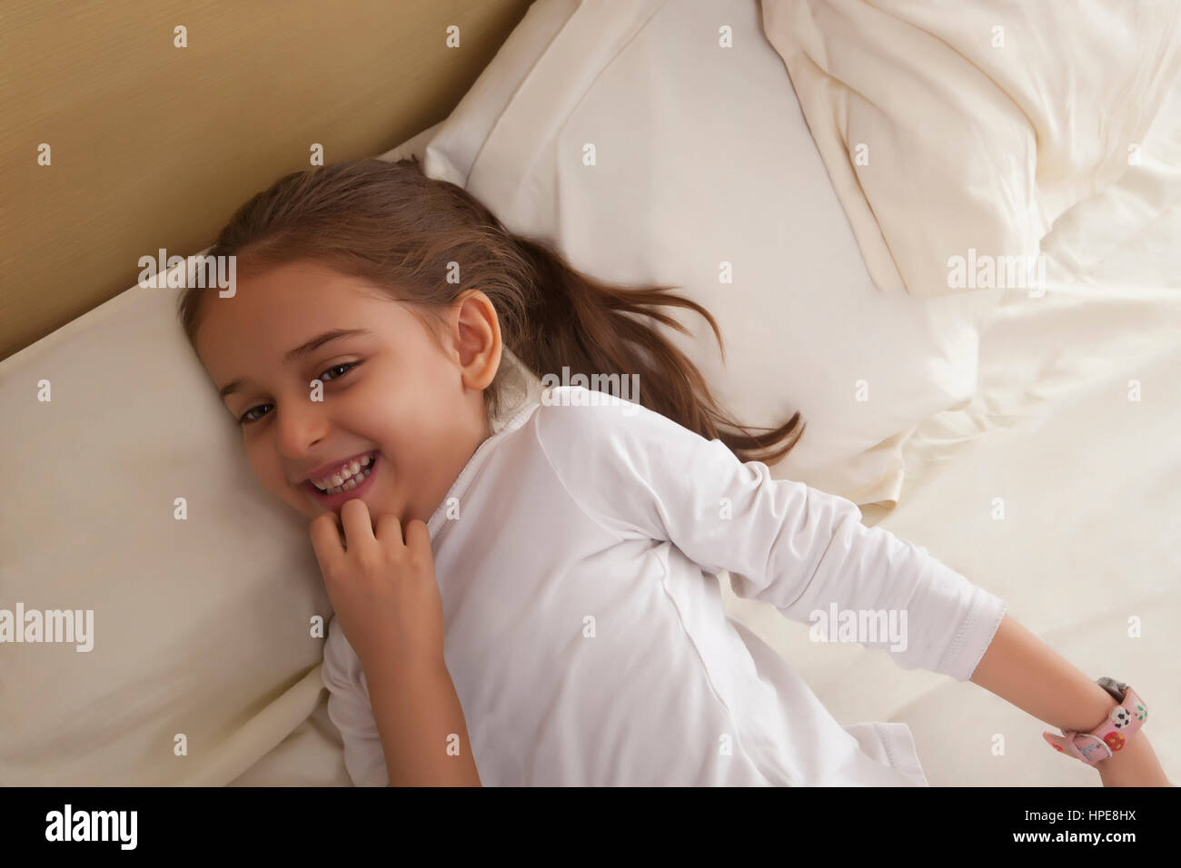 Retrato de niña acostada en la cama Foto de stock
