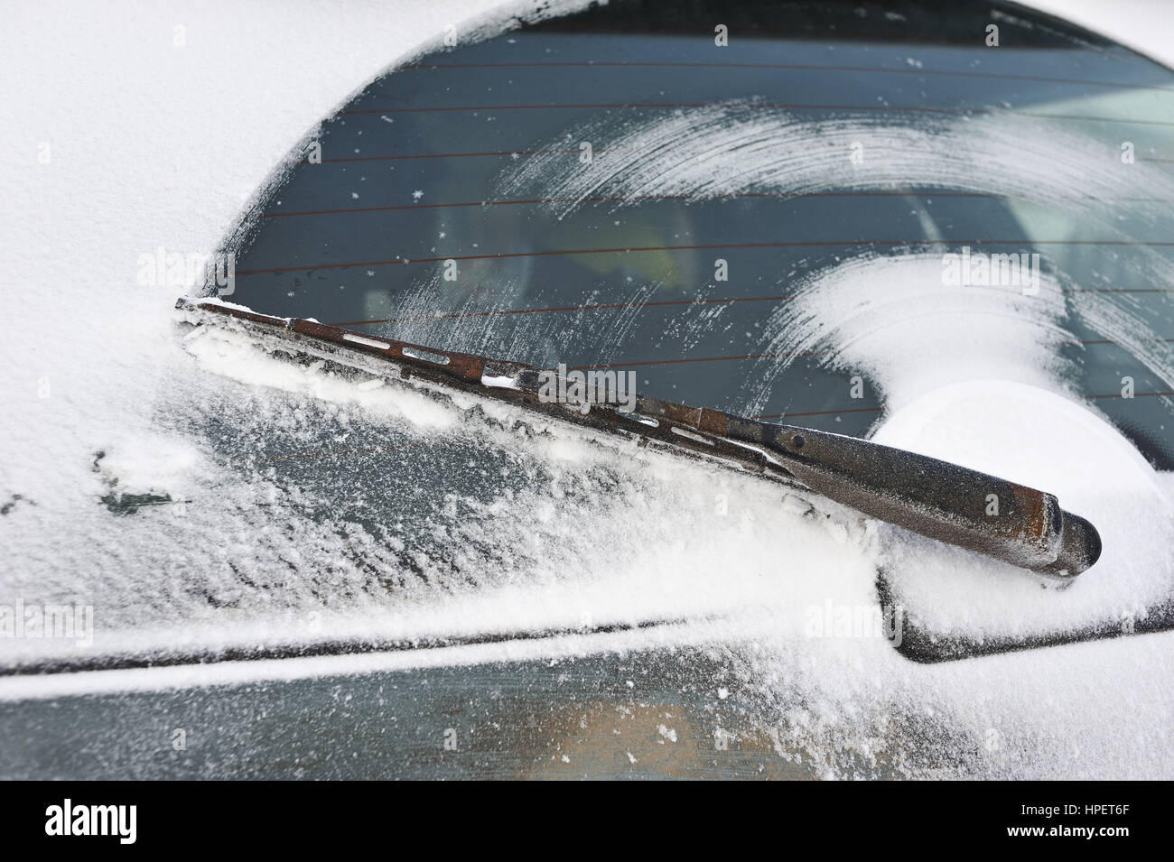 El limpiaparabrisas de la ventana trasera del vagón después de conducir sobre una carretera nevada. Foto de stock