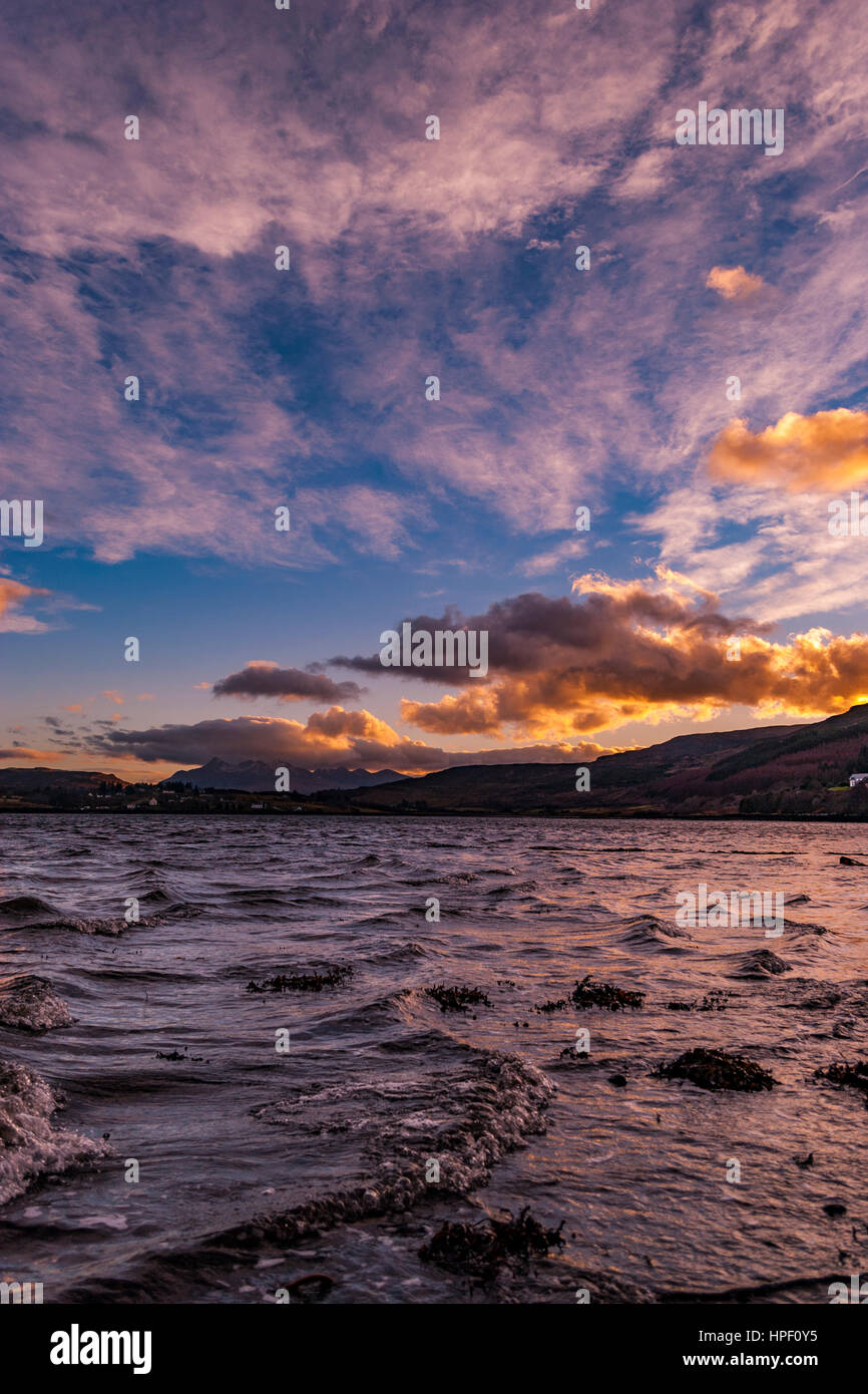 Cordillera Cuillin Hills, a través del lago Portree, en la Isla de Skye, Escocia, contra un cielo dramático, a finales de febrero por la tarde, con nubes iluminadas Foto de stock