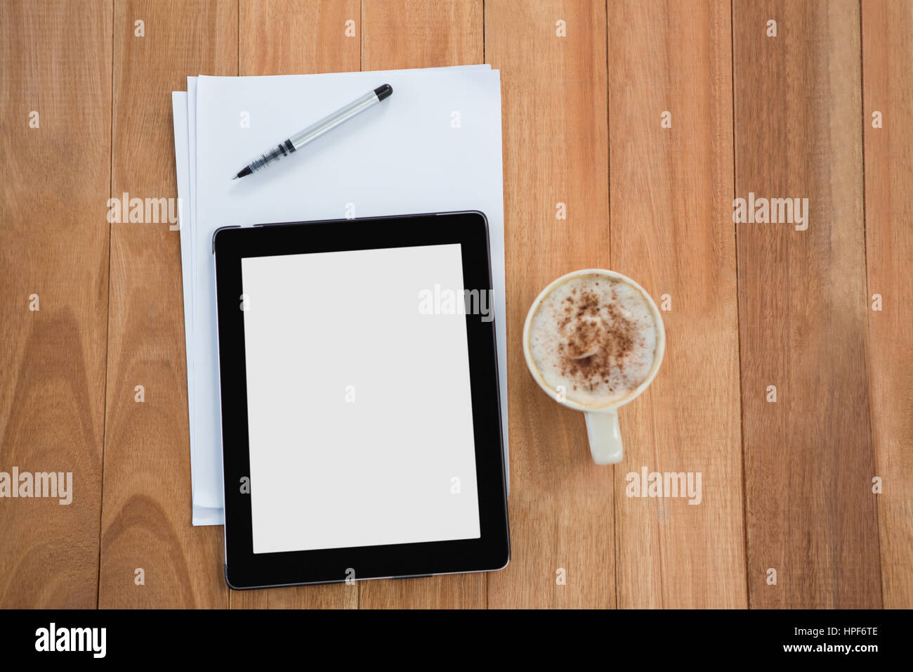 Café con tableta digital y el documento sobre la mesa de madera Foto de stock