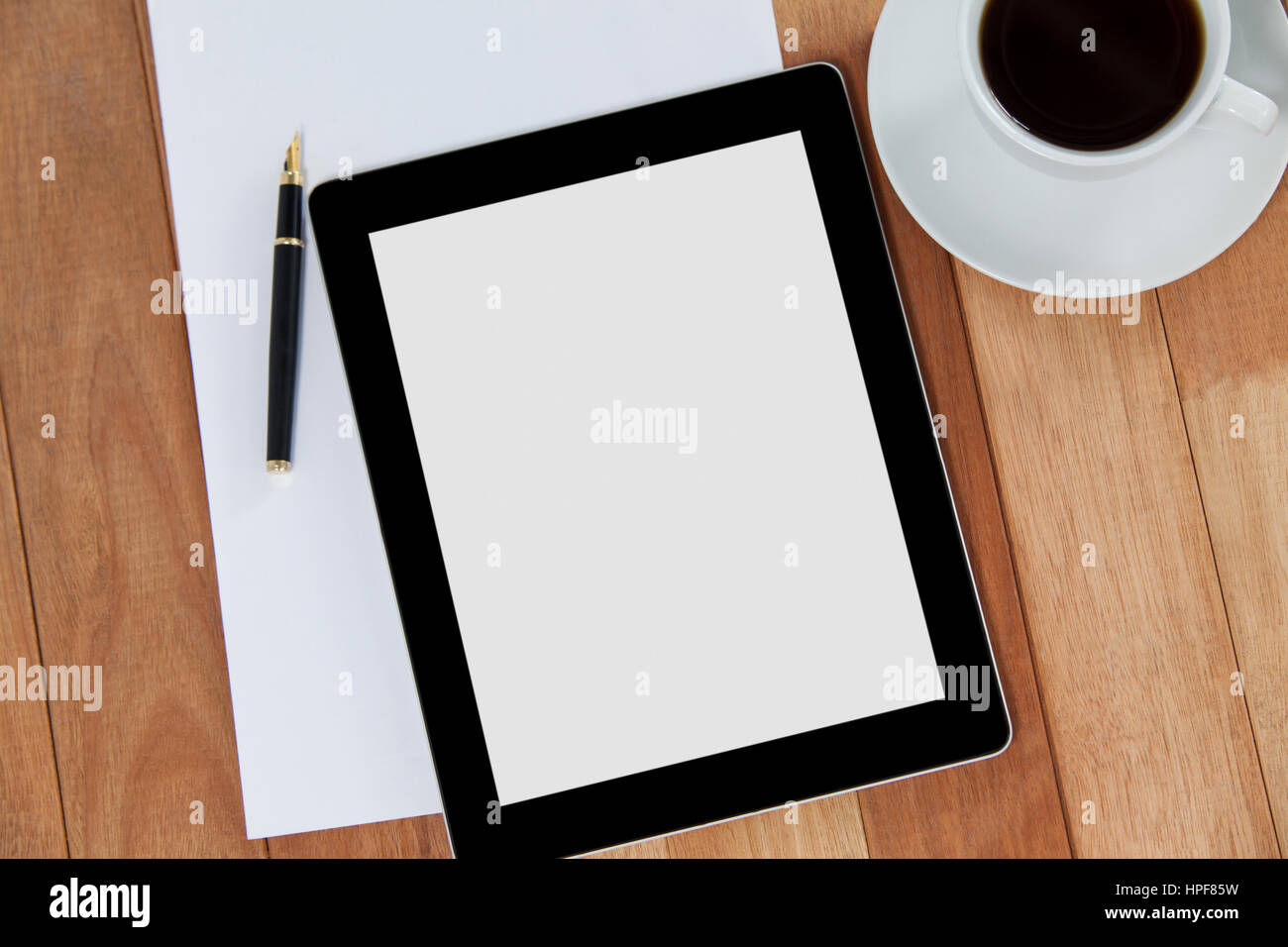 Café negro con la tableta digital y el papel de fondo de madera Foto de stock