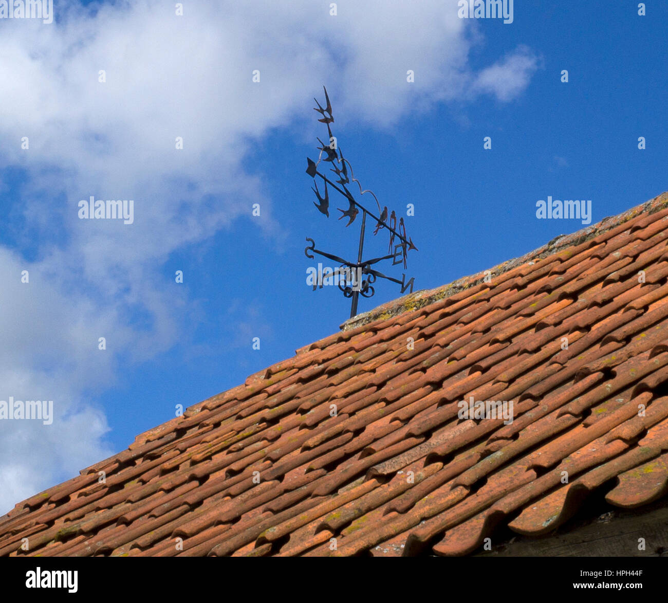 Veleta meteorológica en el techo de baldosas en Lincolnshire, Reino Unido Foto de stock