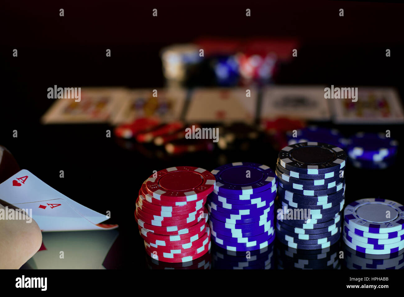 Pareja de ases en el bolsillo y pares de fichas de póquer. Superficie negra, vista horizontal. Foto de stock