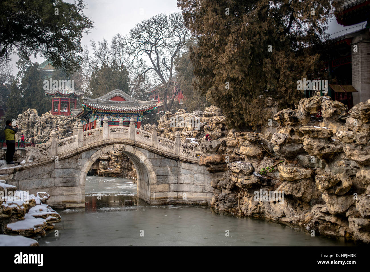 Lago, puente de arco y un pabellón en el jardín chino, el parque Beihai, Beijing, China Foto de stock
