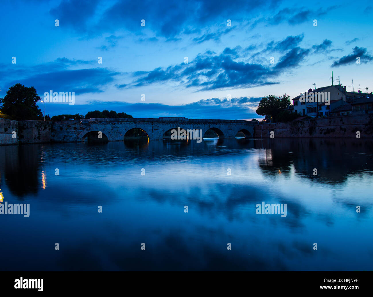 El Puente de Tiberio en Rimini al atardecer. Foto de stock