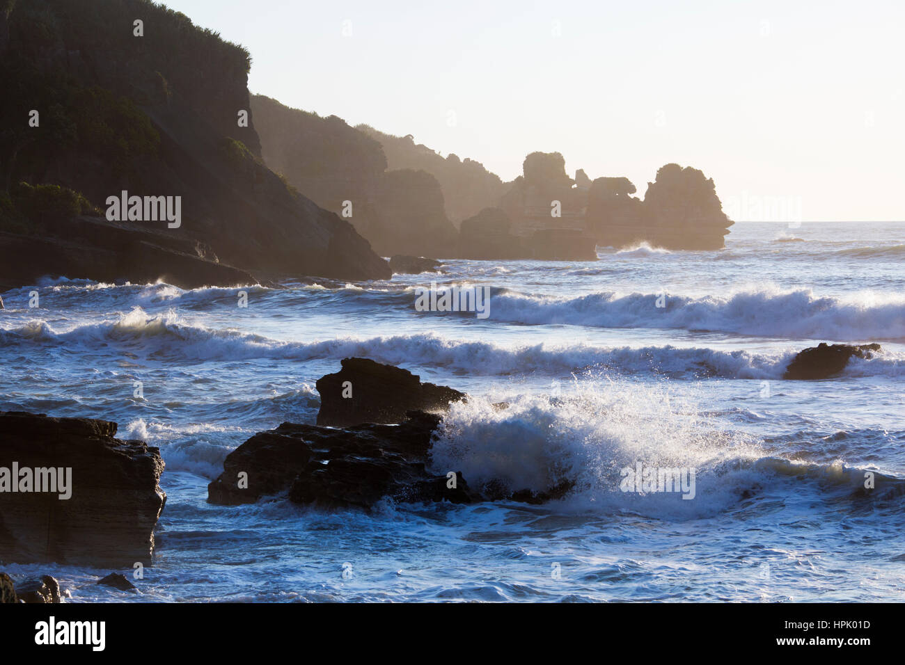 En Punakaiki, Parque Nacional de Paparoa, Costa oeste, Nueva Zelanda. Olas rompiendo contra las rocas en la costa del Mar de Tasmania cerca del punto de Dolomita. Foto de stock