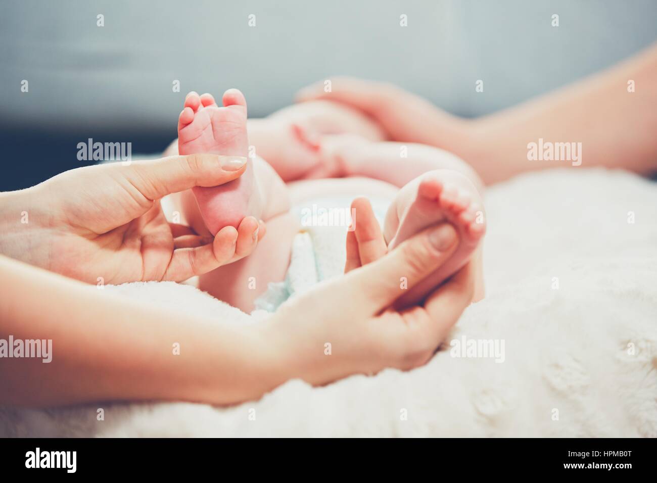 Toque de amor del Padre. Par acariciar su pequeño bebé en la cama. Foto de stock