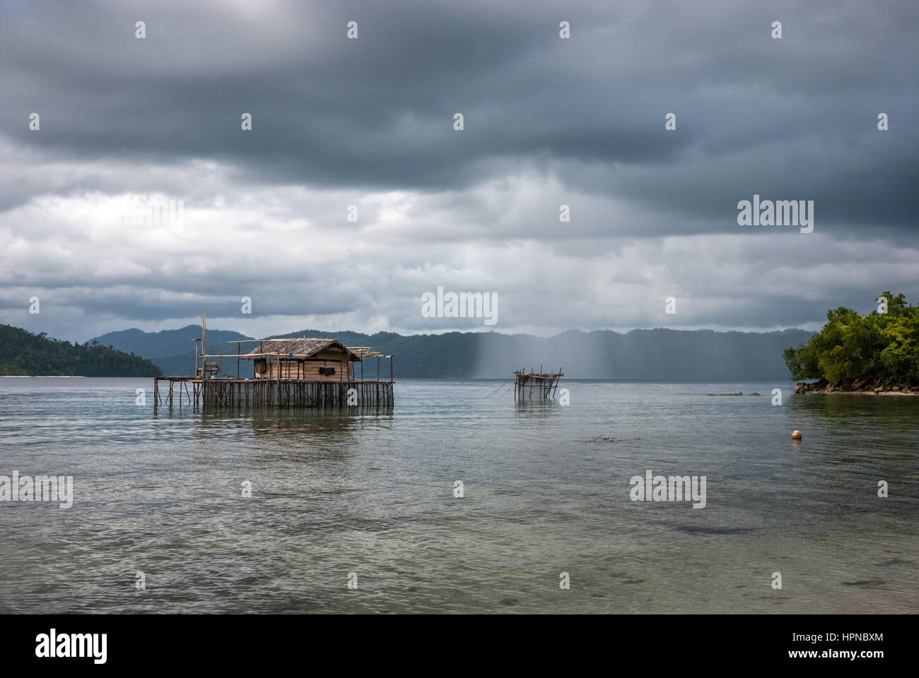 Lluvias aisladas sobre el agua costera de Raja Ampat Islas, Papua Occidental, Indonesia. Foto de stock