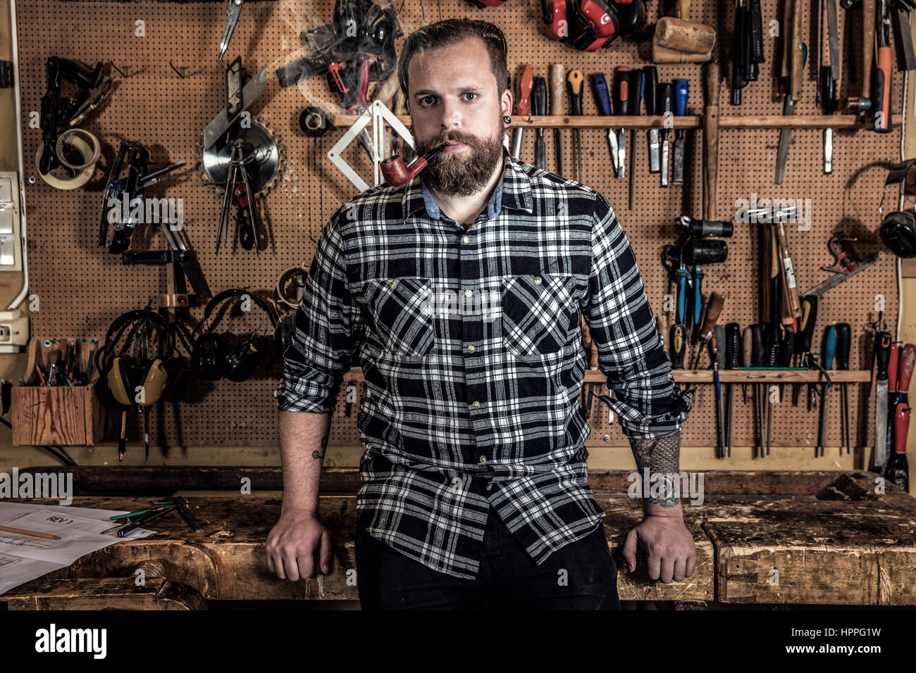 Retrato de un hombre ambiental pipa en madera taller Foto de stock