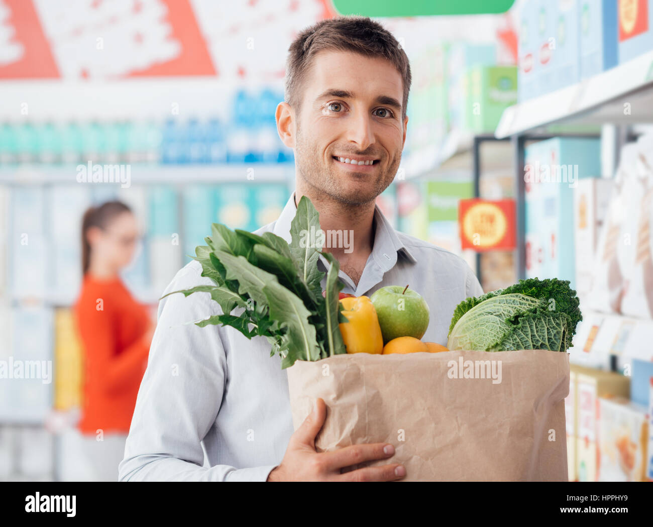 Joven comprar verduras orgánicas frescas en el supermercado Joven comprar verduras orgánicas frescas en el supermercado