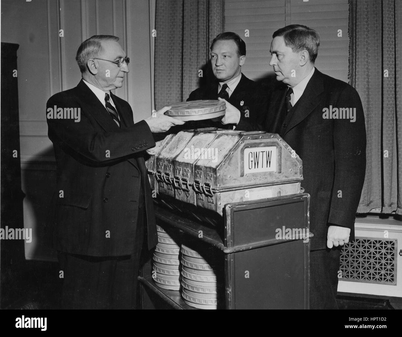 Primer archivero de los Estados Unidos, R. D. W. Connor (derecha) recibe la película "Lo Que el Viento se Llevó" del senador Walter F. George (izquierda) y Carter Barron (centro), gerente de la División Oriental del Loew, 1941. Foto de stock