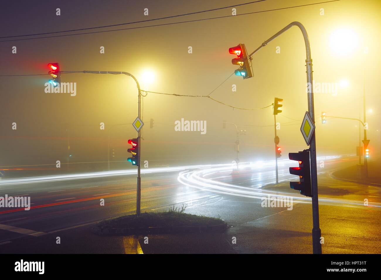 Semáforo, cruce de caminos en la noche neblinosa Foto de stock