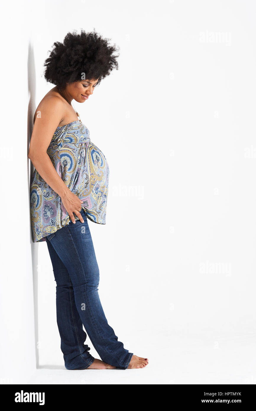 Mujer embarazada contra la pared inclinada Foto de stock