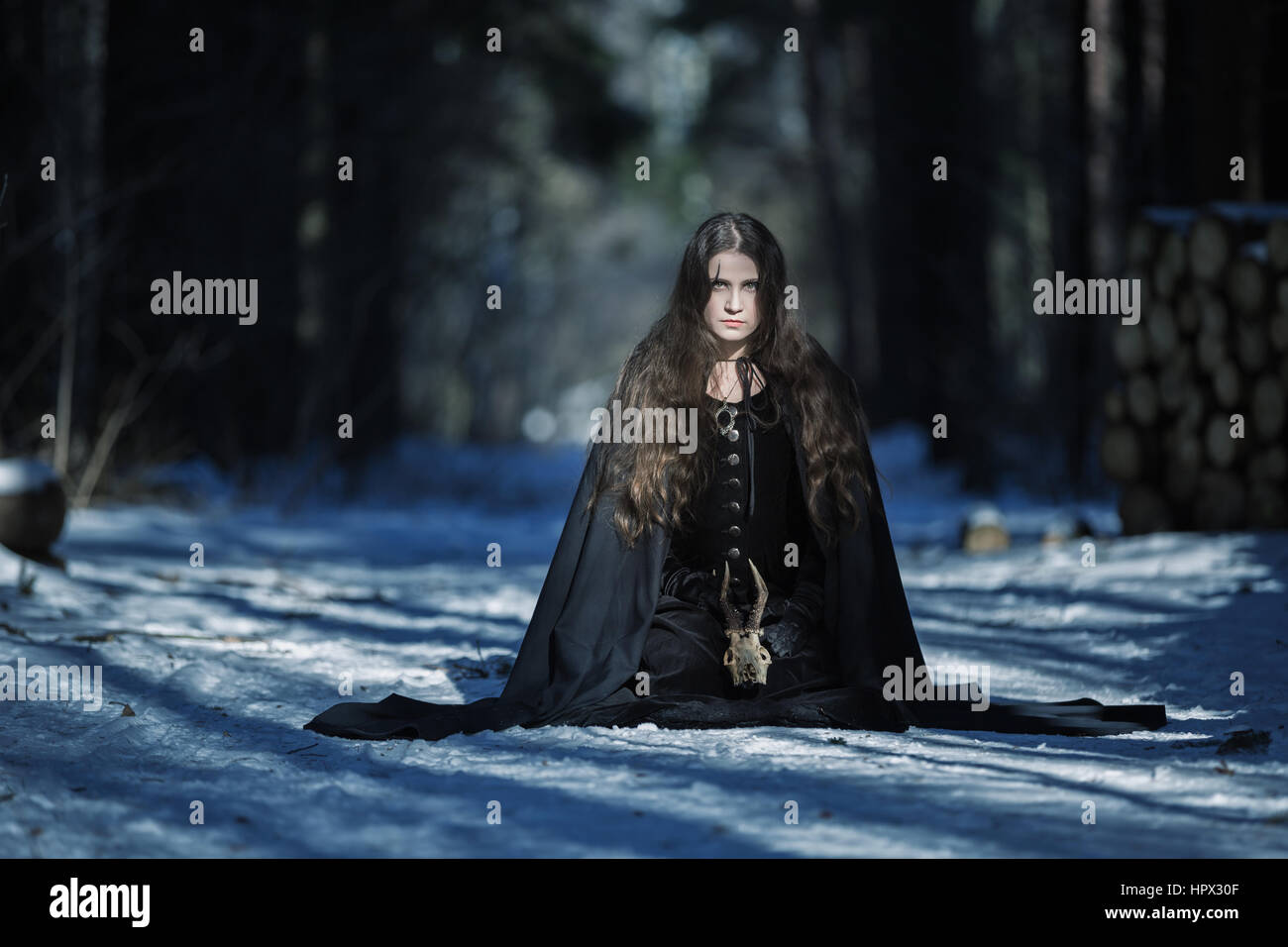 La bruja con una calavera en el bosque Foto de stock