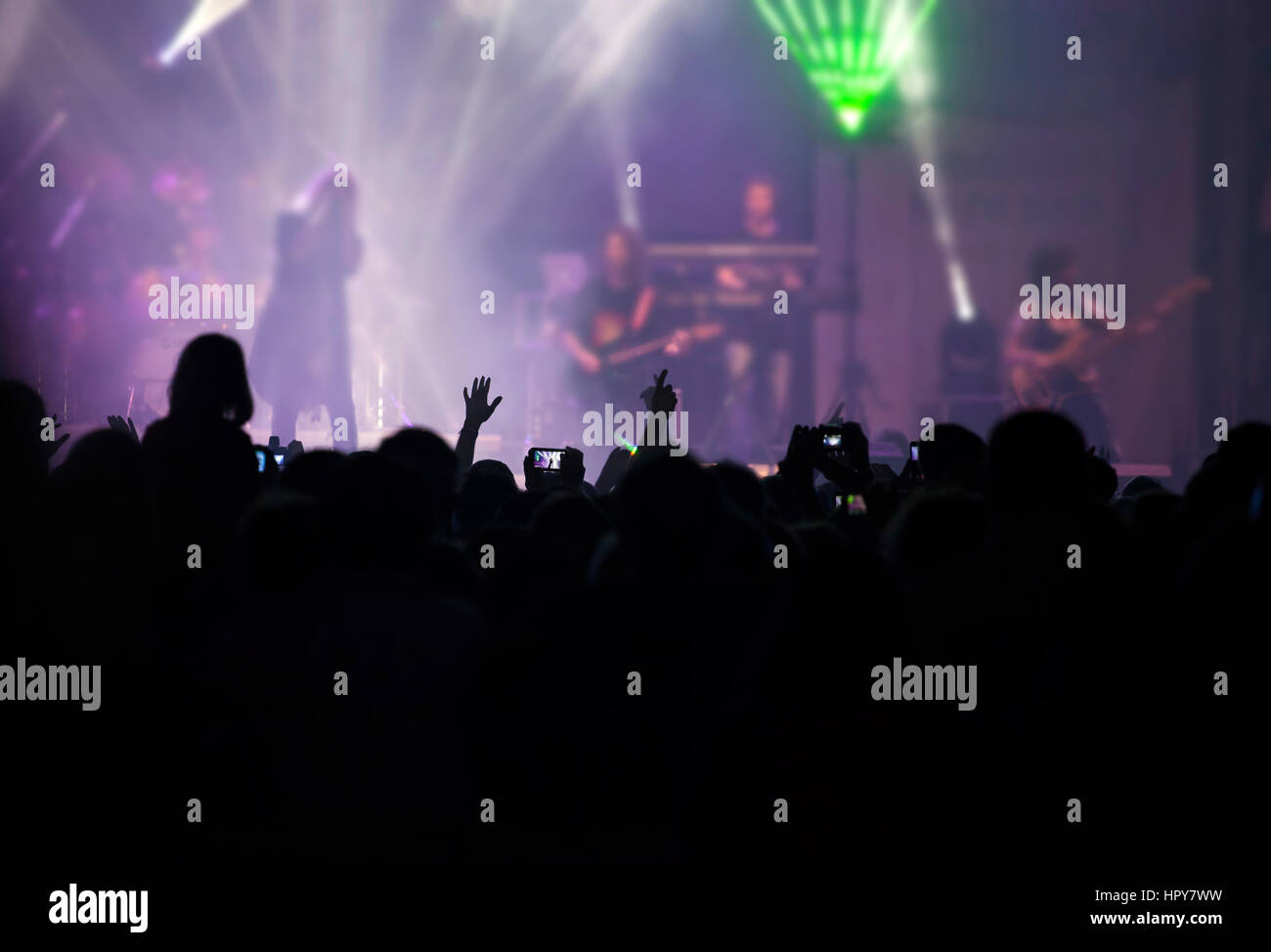 Foto de muchas personas disfrutando de un concierto de rock, la multitud  con las manos levantadas bailando en la discoteca, el público aplaudiendo  al músico de la banda, entretenimiento nocturno Fotografía de