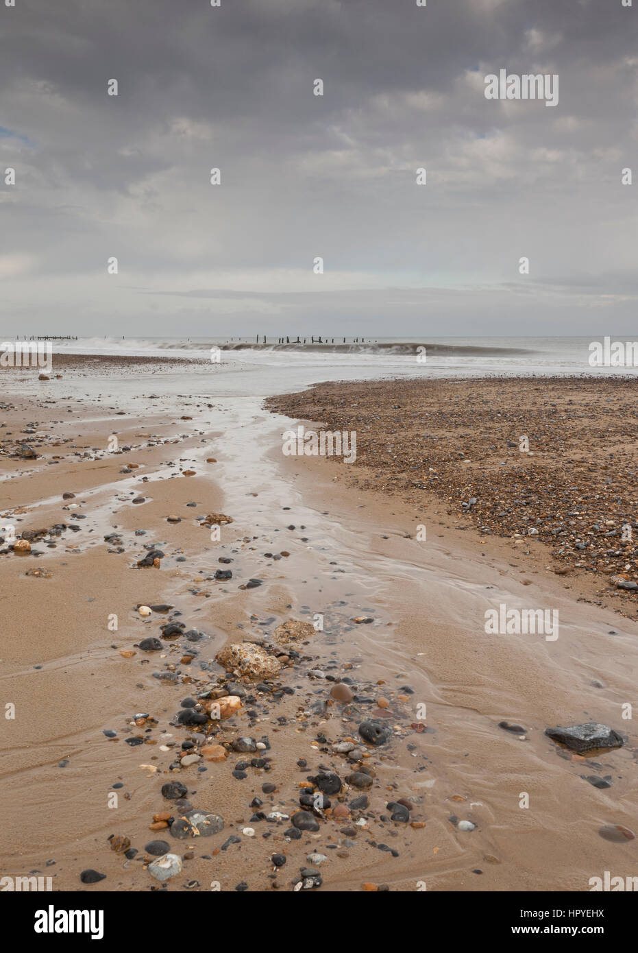 Playa de Happisburgh, Norfolk, Inglaterra. Las defensas marítimas de esta muy erosiva de orilla en un seductor de noviembre día. La marea baja deja patrones de arena Foto de stock