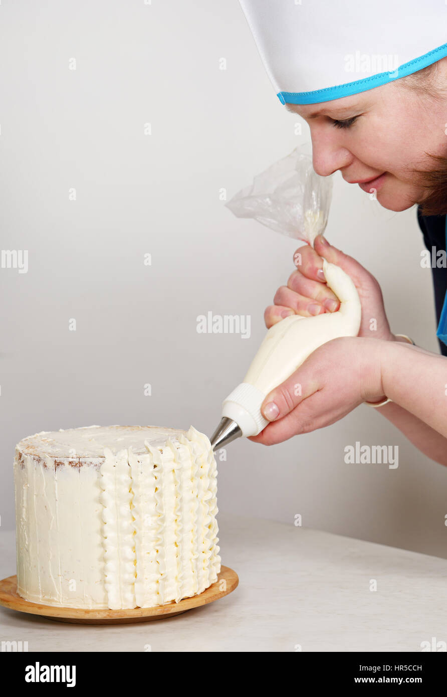 Mujer decorar una torta con crema de patrones Fotografía de stock - Alamy