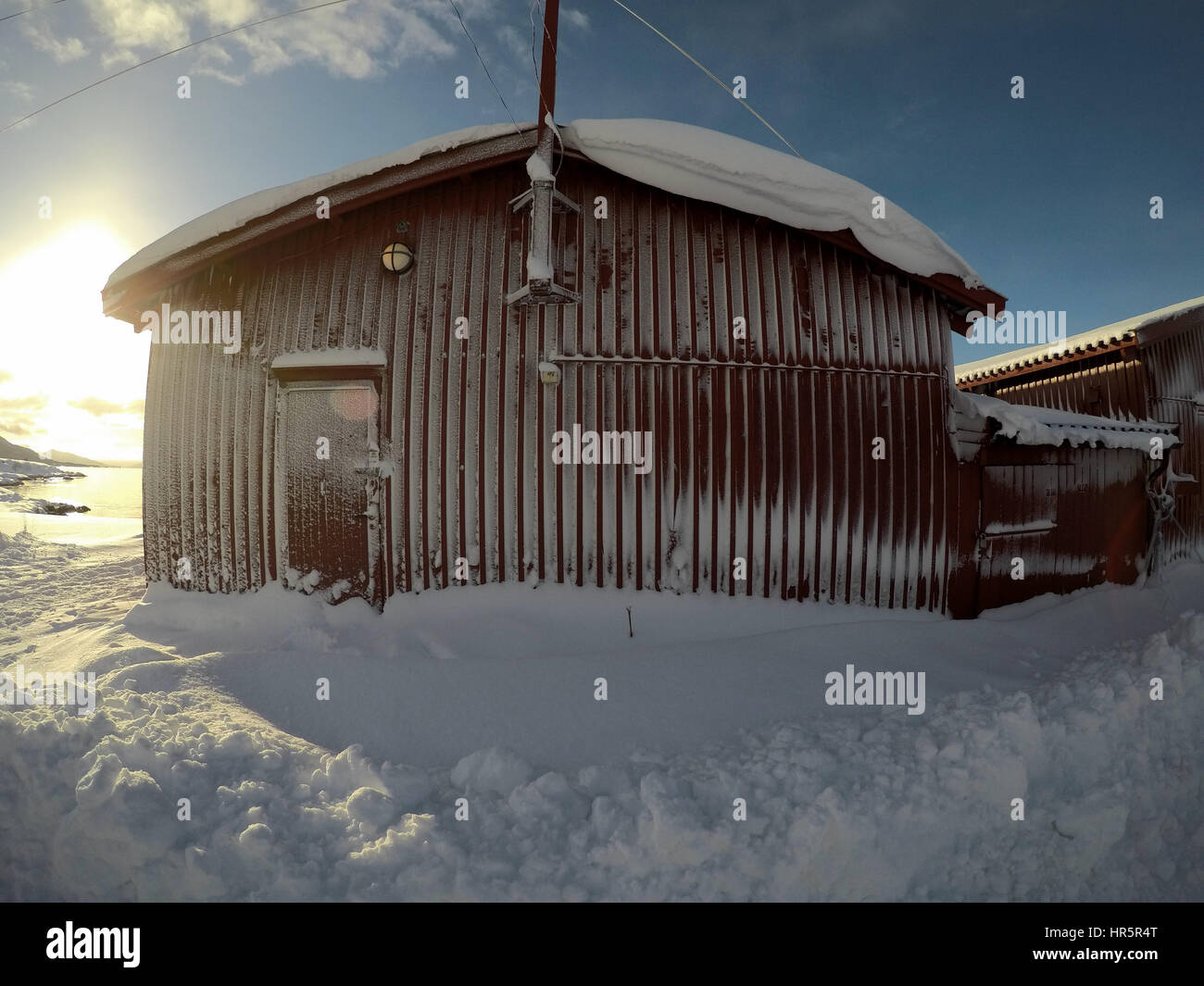 La escarcha y la nieve cubierto rojo boathouse en sunshine Foto de stock