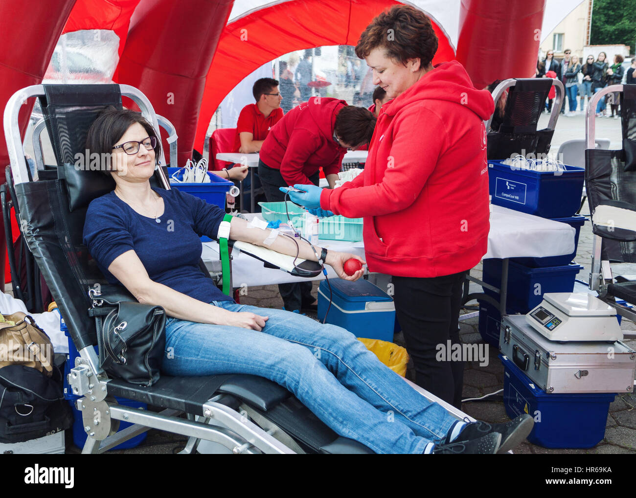 Mujer joven donar sangre en el centro de transfusión móvil en las calles de Vilnius, Lituania. Foto de stock