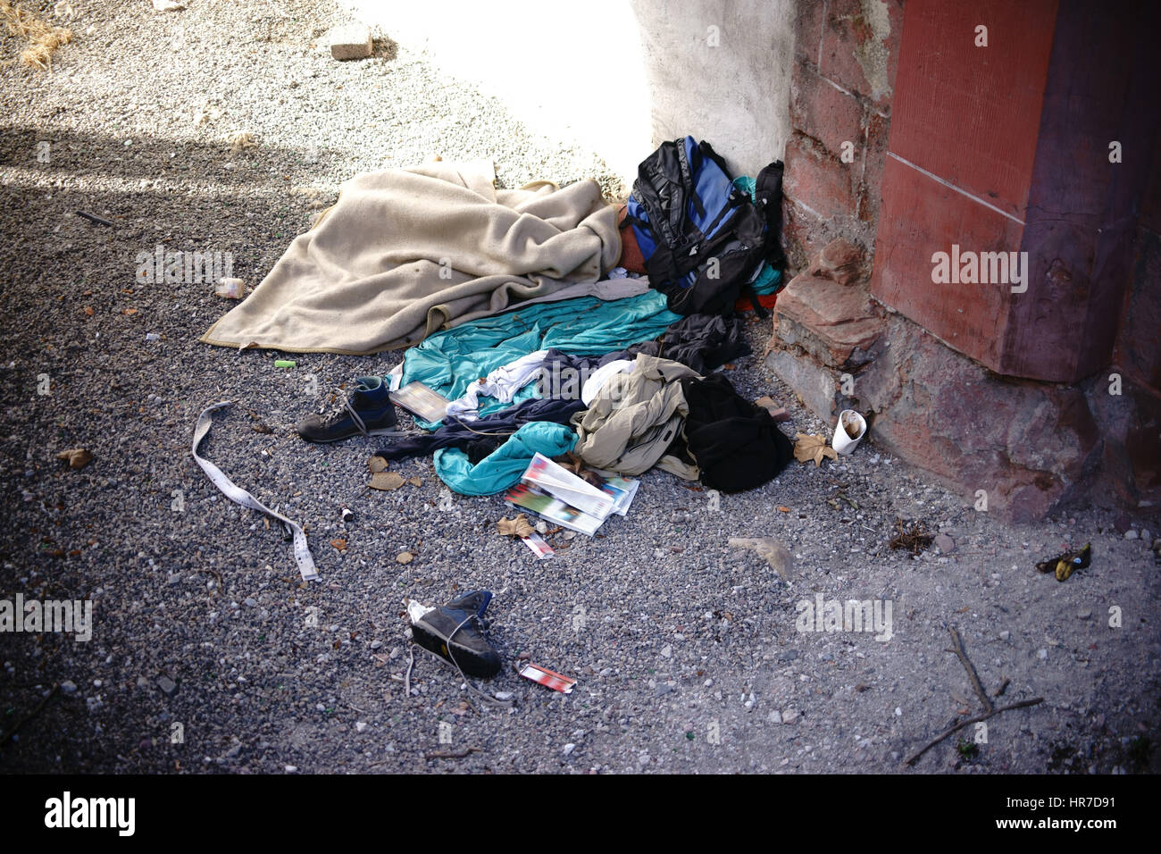 La litera para dormir de un hogar bajo un puente con tapas, basura y restos de alimentos. Foto de stock