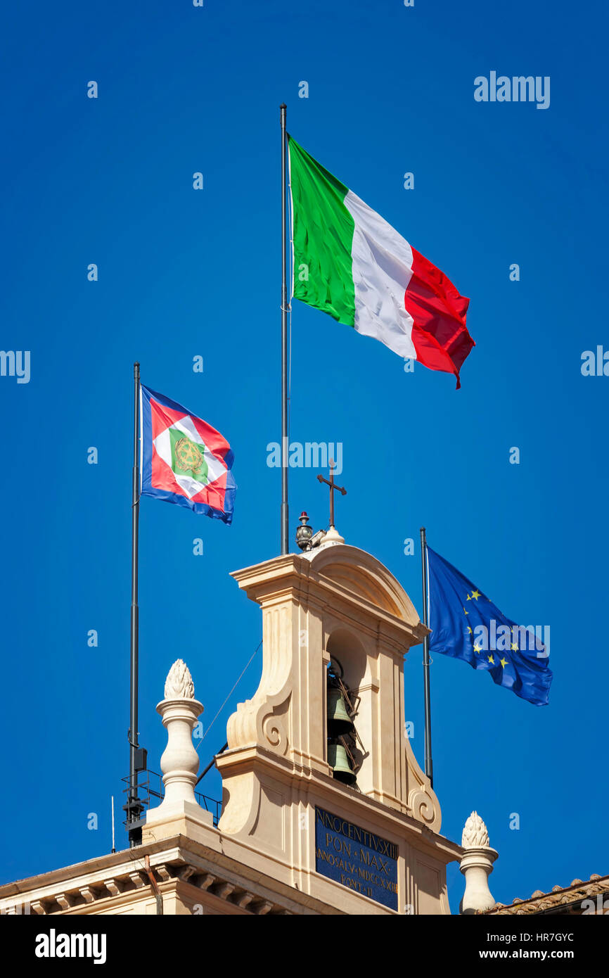 Bandera italiana aparece en el campanario del Quirinal, junto con el banderín presidencial y la bandera de la Unión Europea. Banderas italianas Foto de stock