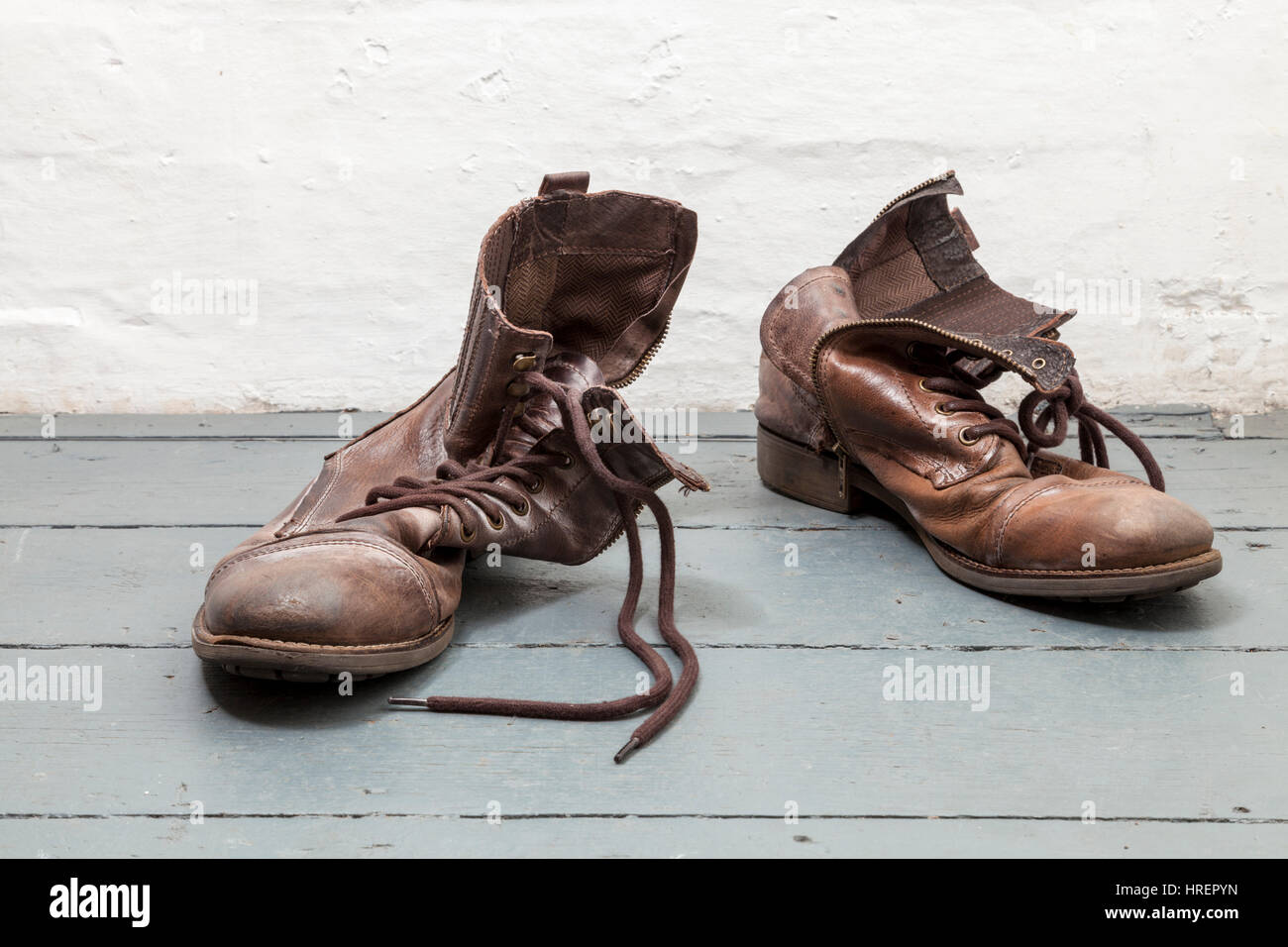 Par de viejas botas de cuero marrón sobre tablas Foto de stock